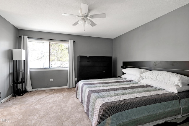 carpeted bedroom with a ceiling fan, baseboards, and a textured ceiling