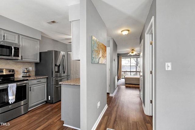 kitchen featuring visible vents, backsplash, gray cabinetry, stainless steel appliances, and a ceiling fan