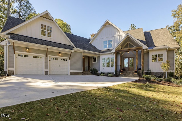 craftsman-style house with a garage, a shingled roof, concrete driveway, board and batten siding, and a front yard