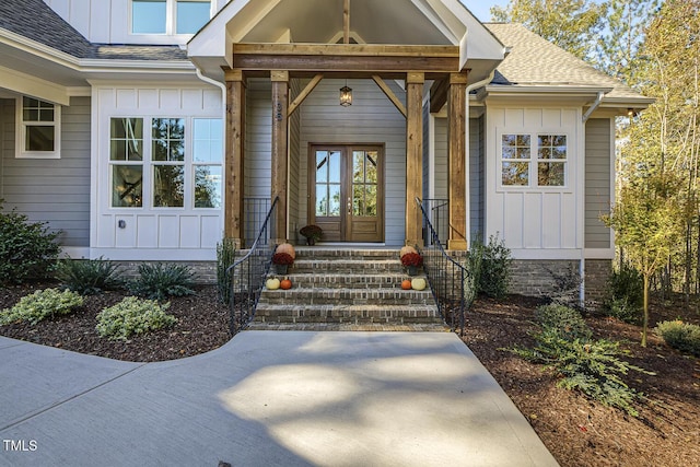 property entrance with board and batten siding and a shingled roof