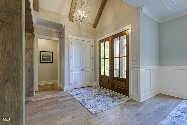 25 Blackhorn Ct, Pittsboro, NC 27312 - entrance foyer featuring lofted ceiling, a wainscoted wall, light wood-style flooring, an inviting chandelier, and french doors