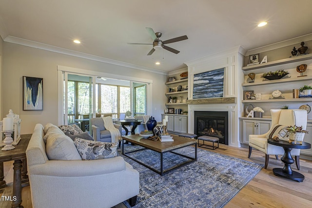 25 Blackhorn Ct, Pittsboro, NC 27312 - living room featuring light wood finished floors, a ceiling fan, crown molding, and a glass covered fireplace