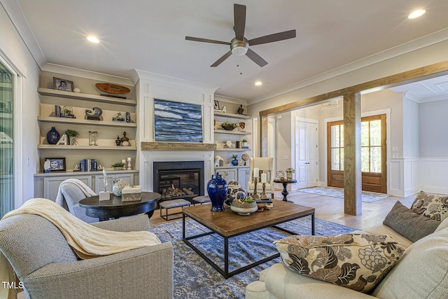 25 Blackhorn Ct, Pittsboro, NC 27312 - living room with built in shelves, a wainscoted wall, recessed lighting, ornamental molding, and a glass covered fireplace