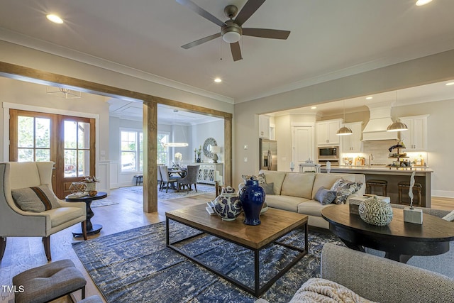 25 Blackhorn Ct, Pittsboro, NC 27312 - living area featuring crown molding, recessed lighting, a decorative wall, wainscoting, and light wood-type flooring