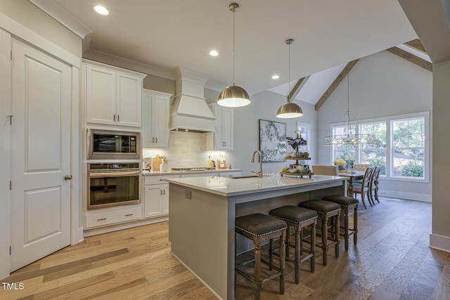 25 Blackhorn Ct, Pittsboro, NC 27312 - kitchen featuring a center island with sink, stainless steel appliances, light countertops, white cabinets, and premium range hood