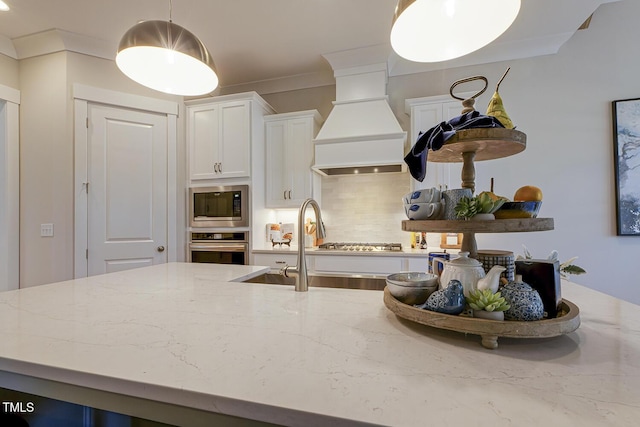 25 Blackhorn Ct, Pittsboro, NC 27312 - kitchen featuring appliances with stainless steel finishes, light stone counters, hanging light fixtures, premium range hood, and backsplash