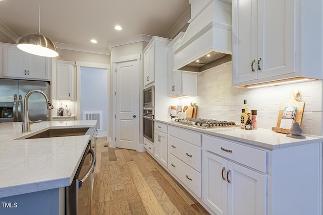 25 Blackhorn Ct, Pittsboro, NC 27312 - kitchen featuring light stone counters, decorative light fixtures, appliances with stainless steel finishes, white cabinetry, and premium range hood