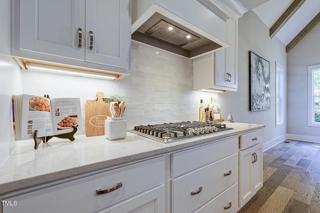 25 Blackhorn Ct, Pittsboro, NC 27312 - kitchen with light stone counters, vaulted ceiling with beams, stainless steel gas cooktop, custom exhaust hood, and white cabinetry
