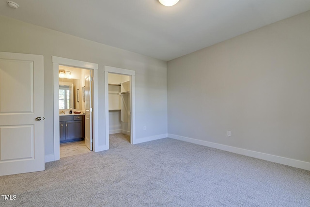 25 Blackhorn Ct, Pittsboro, NC 27312 - unfurnished bedroom featuring a closet, light colored carpet, a spacious closet, ensuite bath, and baseboards