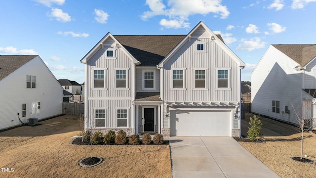 view of front of house with board and batten siding, stone siding, driveway, and a garage