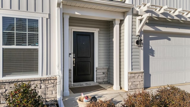 entrance to property with board and batten siding and stone siding