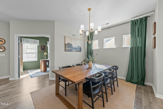 dining space featuring wood finished floors, visible vents, and baseboards