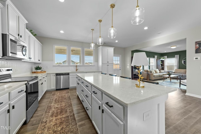 kitchen featuring appliances with stainless steel finishes, a kitchen island, and white cabinetry