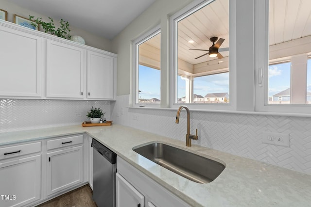 kitchen with a healthy amount of sunlight, white cabinets, dishwasher, and a sink