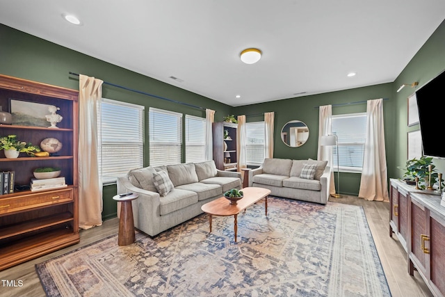 living area with light wood-style flooring and recessed lighting