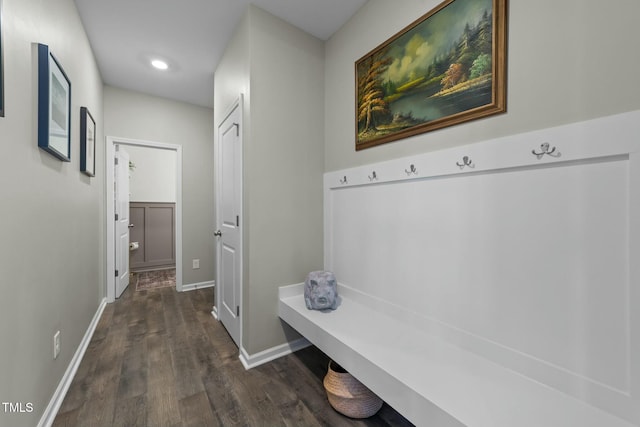 mudroom with dark wood finished floors and baseboards