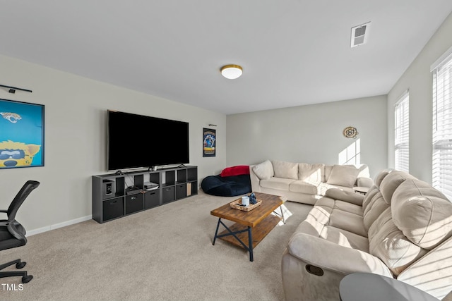 living room with carpet floors, visible vents, and baseboards