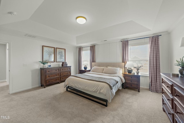 bedroom featuring light carpet, visible vents, a tray ceiling, and baseboards