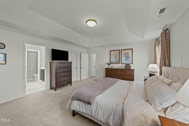 bedroom featuring ensuite bathroom, light carpet, visible vents, baseboards, and a raised ceiling