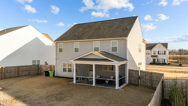 rear view of house featuring a yard, a patio area, a fenced backyard, and a sunroom