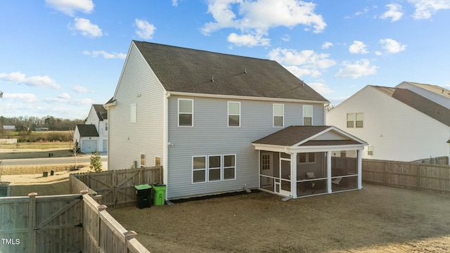 back of property with a sunroom, a fenced backyard, a gate, and roof with shingles