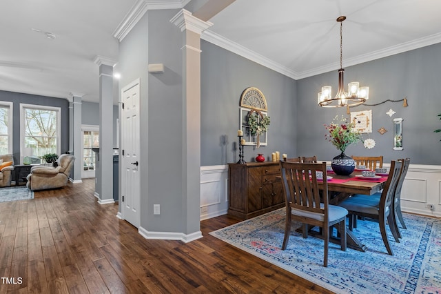 dining area with crown molding, dark wood-type flooring, and decorative columns