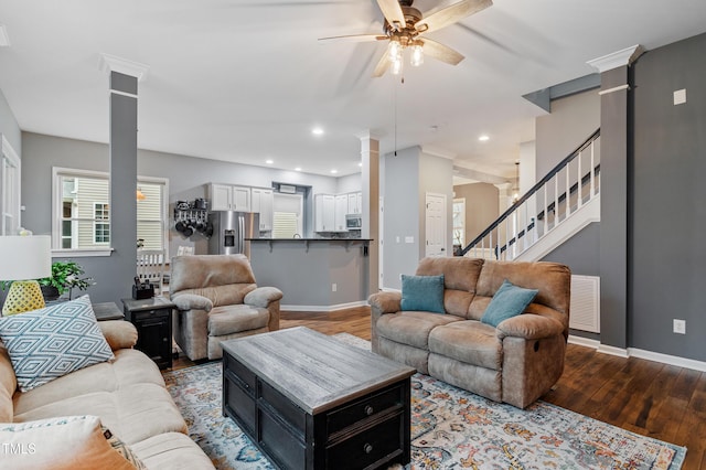 living area with visible vents, stairs, hardwood / wood-style floors, decorative columns, and a ceiling fan