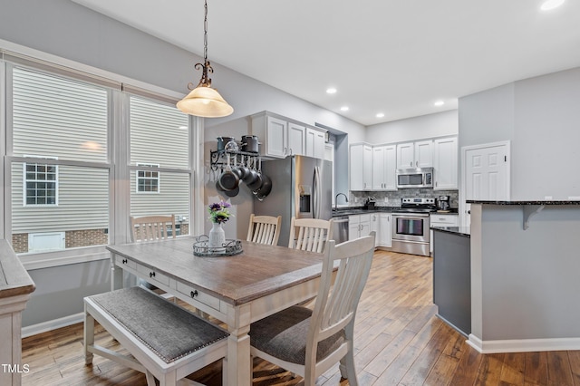 dining room with recessed lighting, baseboards, and light wood-style floors