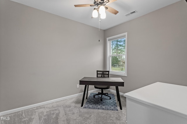 home office with light carpet, visible vents, baseboards, and a ceiling fan