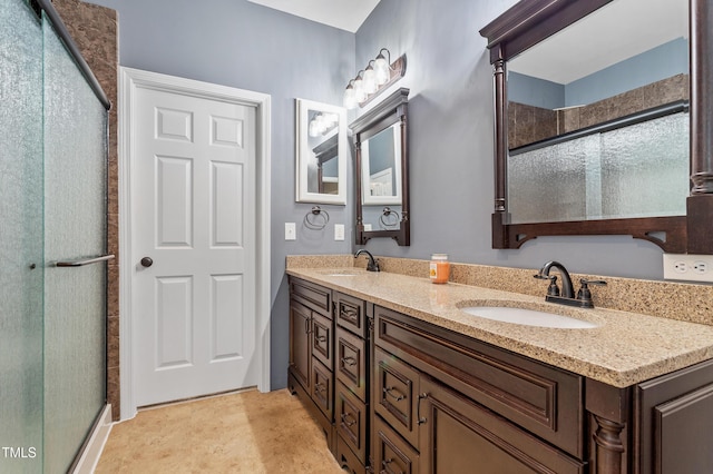 full bathroom featuring double vanity, an enclosed shower, and a sink