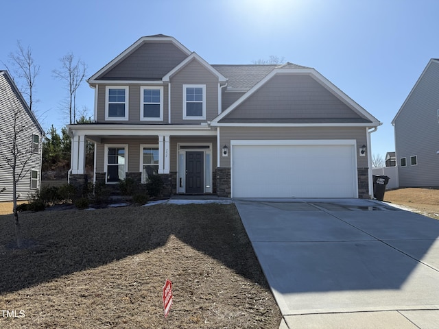 craftsman-style house featuring a garage, stone siding, a porch, and concrete driveway