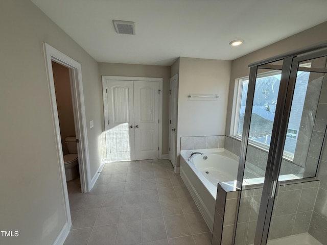 bathroom with a closet, visible vents, toilet, baseboards, and a bath