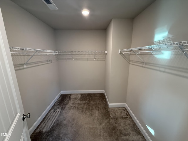 spacious closet featuring visible vents and dark carpet