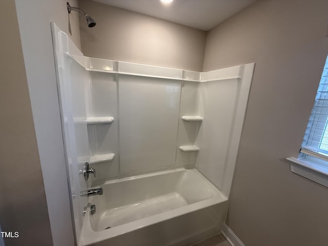 full bath featuring baseboards and shower / tub combination