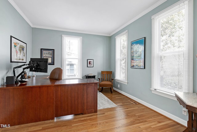 home office with visible vents, light wood-type flooring, baseboards, and ornamental molding