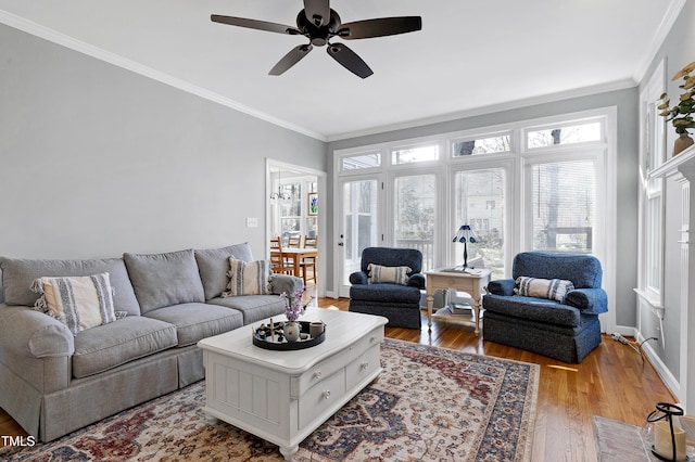 living area with crown molding, wood finished floors, and ceiling fan