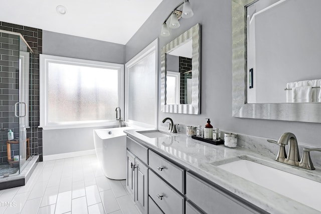 bathroom with a sink, a freestanding tub, a stall shower, and double vanity