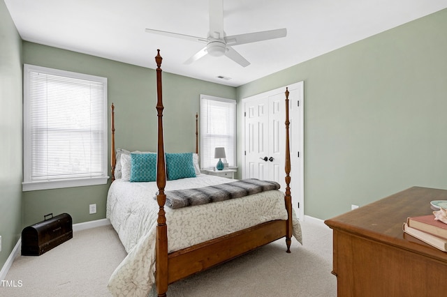 carpeted bedroom with baseboards, multiple windows, and a ceiling fan