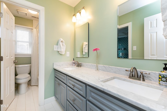 bathroom with double vanity, visible vents, toilet, and a sink