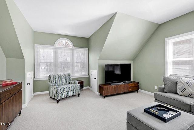 living area featuring visible vents, baseboards, light colored carpet, and vaulted ceiling