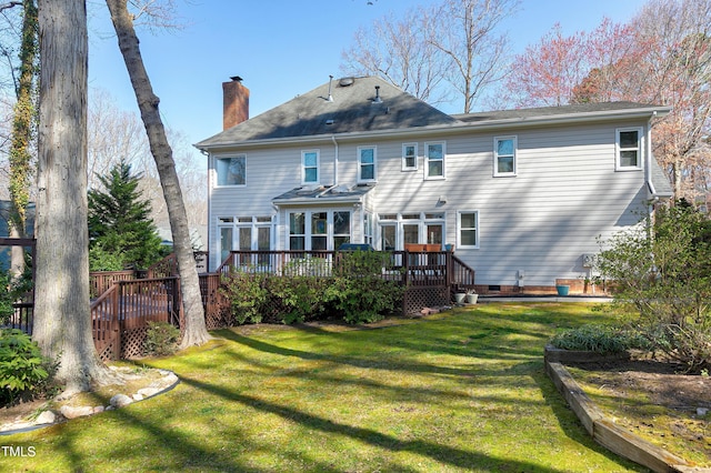 back of property featuring crawl space, a wooden deck, a yard, and a chimney