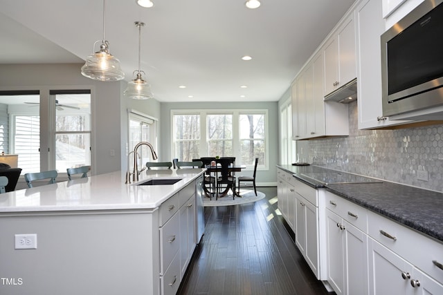 kitchen with a sink, backsplash, dark wood-style floors, recessed lighting, and stainless steel appliances