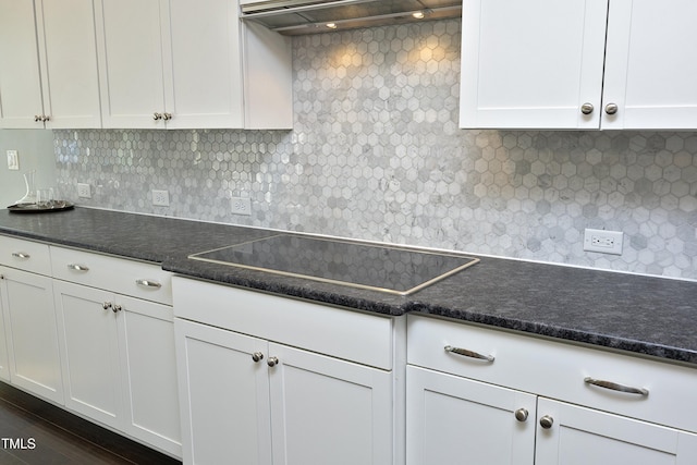 kitchen featuring dark countertops, black electric stovetop, and exhaust hood