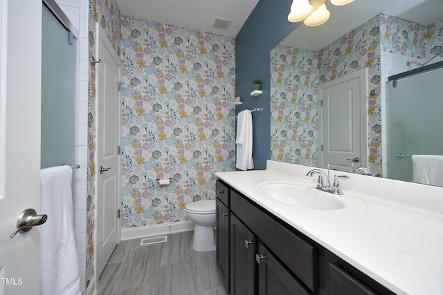 bathroom with wallpapered walls, a shower stall, toilet, and visible vents