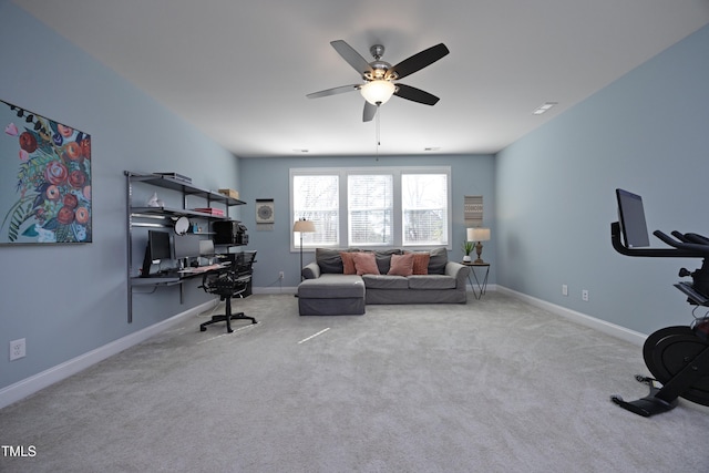 carpeted office space with ceiling fan and baseboards