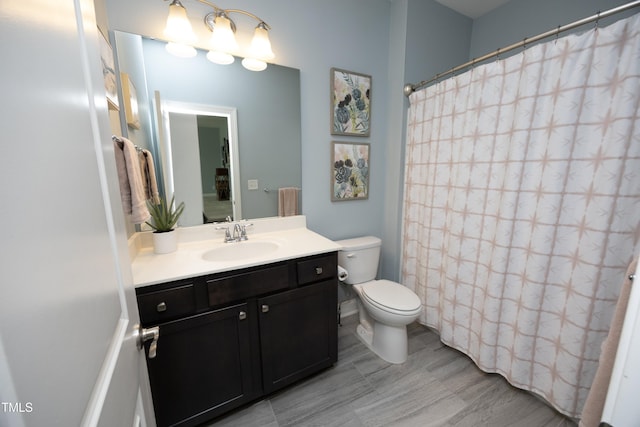 bathroom with curtained shower, toilet, and vanity