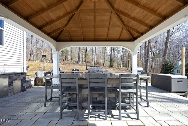 view of patio featuring outdoor dining space, a gazebo, and a sink