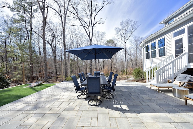 view of patio / terrace with outdoor dining space and a forest view