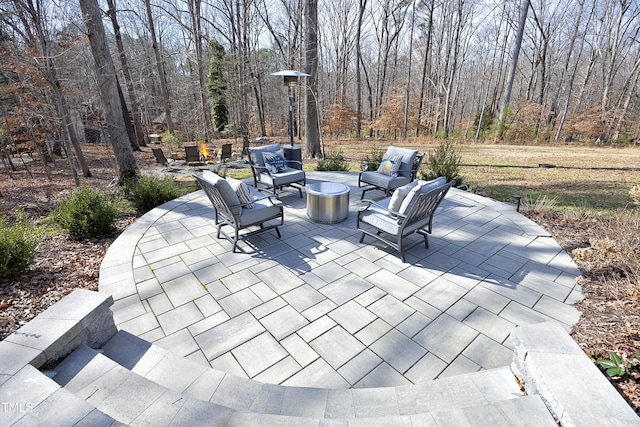 view of patio with a fire pit and a wooded view