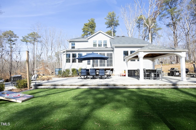 back of property featuring a gazebo, a lawn, outdoor dining area, and a deck